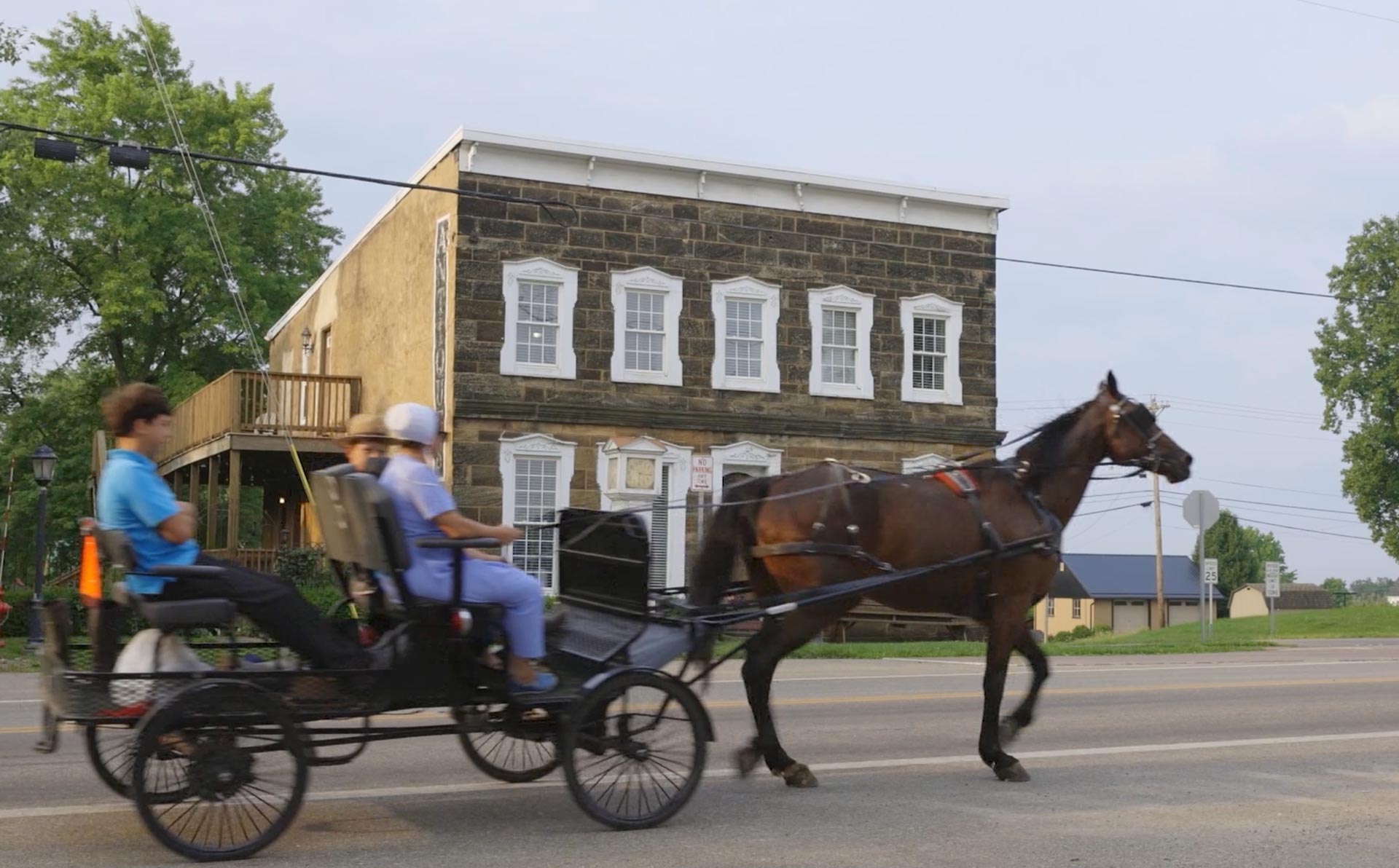 An Amish family on a horse and buggy rides by the Plain Values office in Winesburg, Ohio.